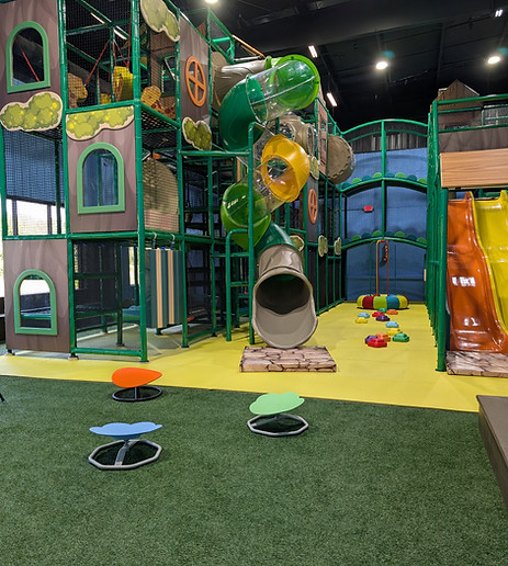 Children climbing and sliding in the indoor playground at The Bee’s Knees Play Cafe, Arab AL.