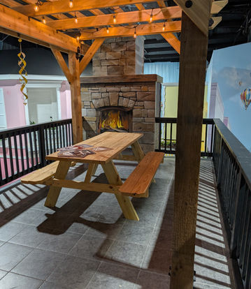 The Bees Knees Play Cafe Picnic Table under a wooden structure with a pretend fire place